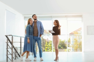 Real estate agent showing happy couple around a home